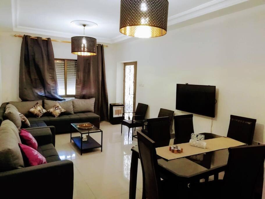uma sala de estar com um sofá e uma mesa em Apartment with terrace garden em Amã