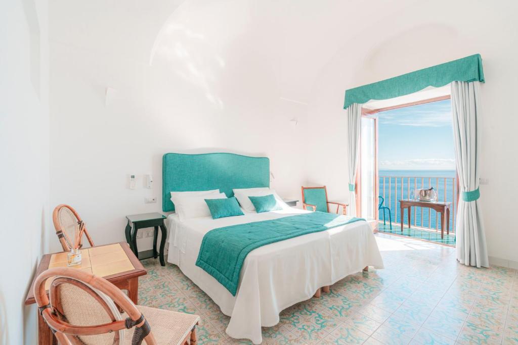 a bedroom with a bed and a large window at Villa Nettuno in Positano