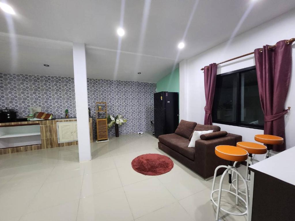 een woonkamer met een bank en een aantal stoelen bij Phanason Private Home soi 4 in Kathu