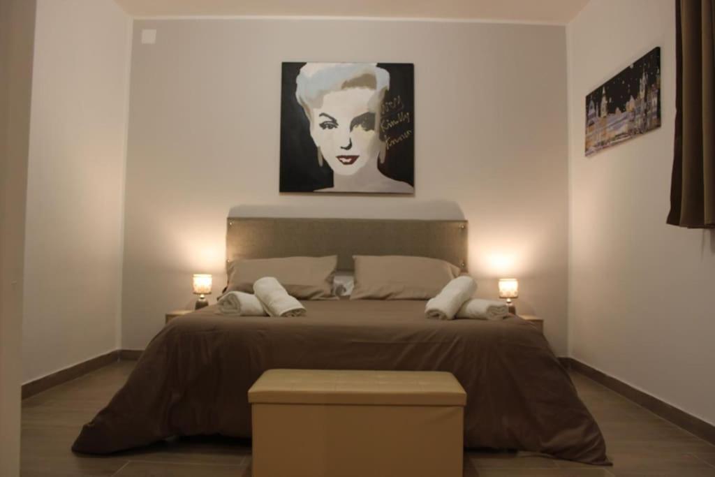 Schlafzimmer mit einem Bett mit Wandgemälde in der Unterkunft Casetta Dante 130 in Palermo