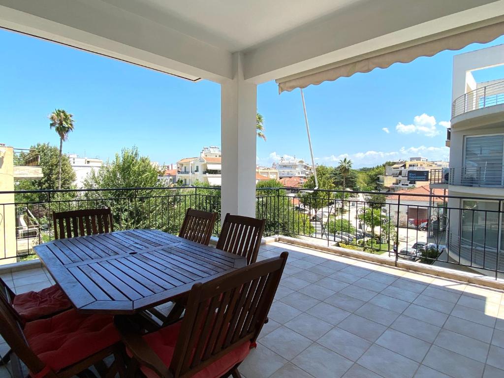 a patio with a table and chairs on a balcony at Sunny Apartment Amaliada in Amaliás