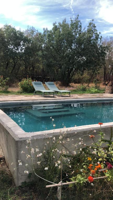 una piscina con 2 sillas y un banco en Las Casas del Palomar I & II, en Ortigosa del Monte