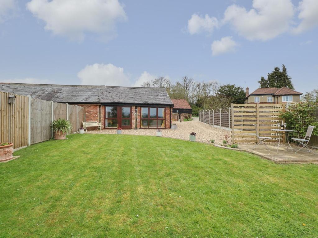 a barn conversion with a lawn in front of it at Bee Happy Barn in Norwich