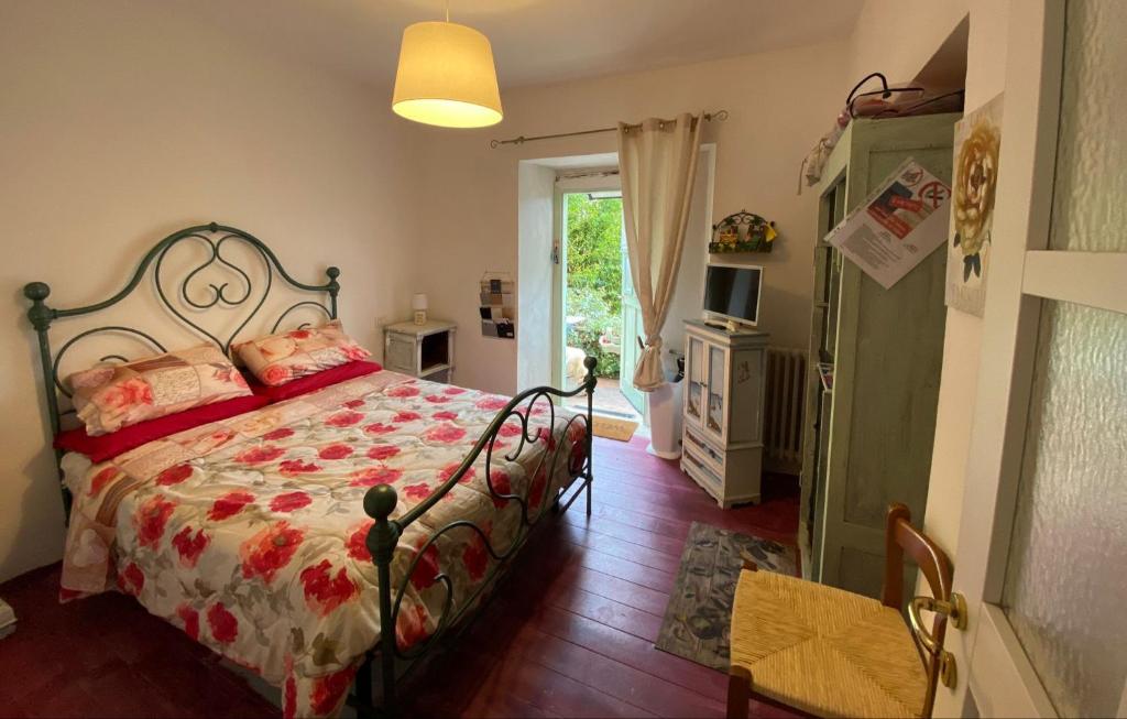 a bedroom with a bed with a red comforter at L'ANGOLINO, Casale vita nova in Manciano