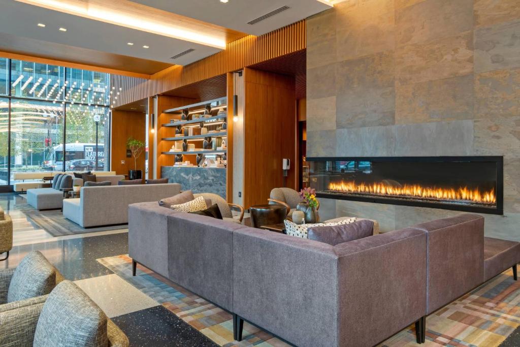 a living room with a fireplace and couches at AC Hotel by Marriott Washington DC Convention Center in Washington