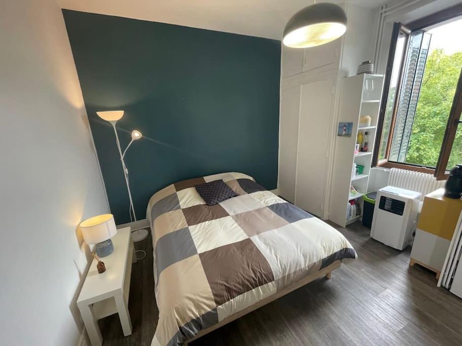 une chambre avec un lit et un mur bleu dans l'établissement Très beau studio centre ville, au calme, à Annecy