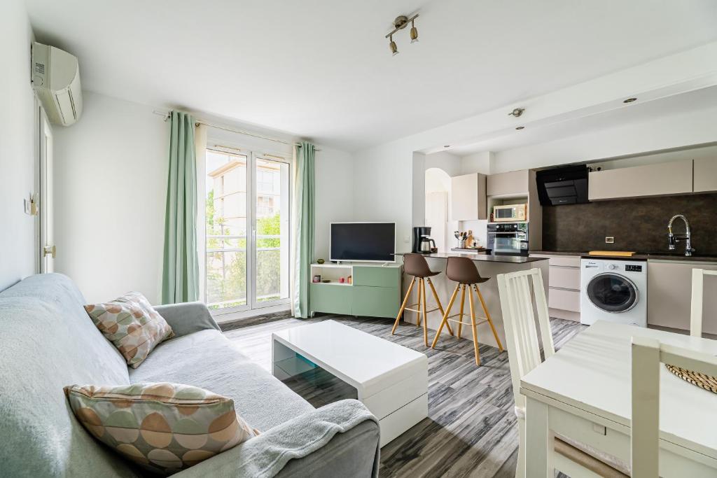 uma sala de estar com um sofá e uma cozinha em Appartement tout équipé em Marselha