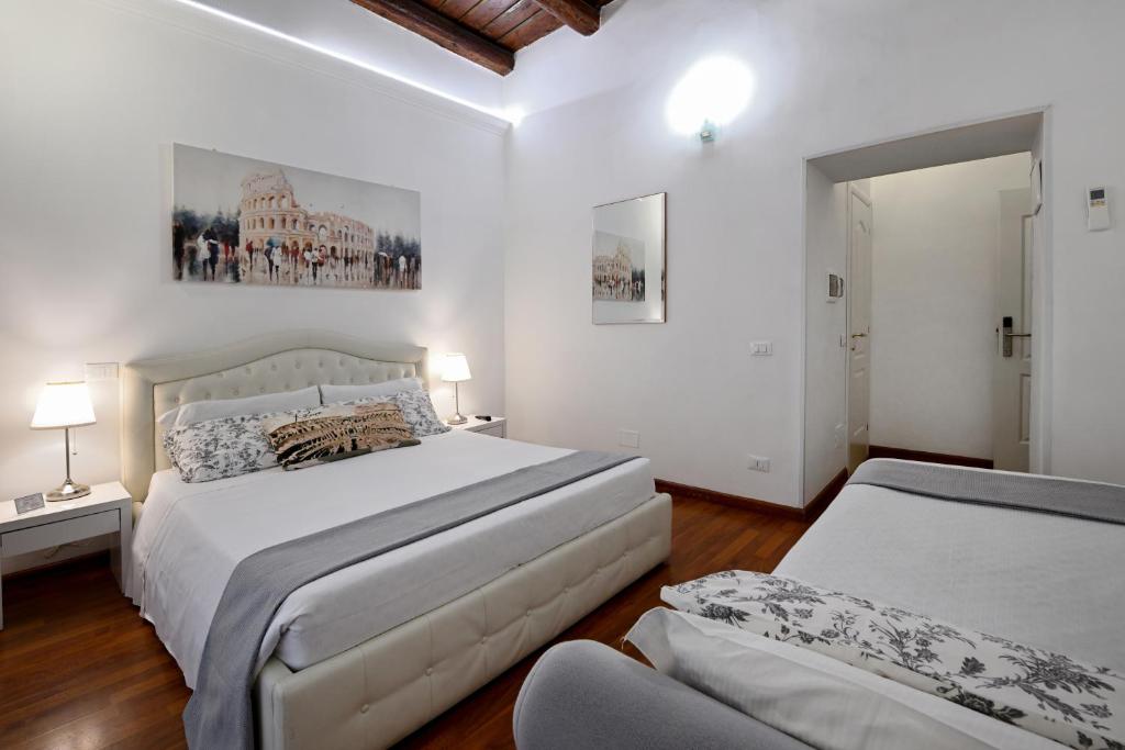 1 dormitorio blanco con 2 camas y sofá en Notti A Roma, en Roma