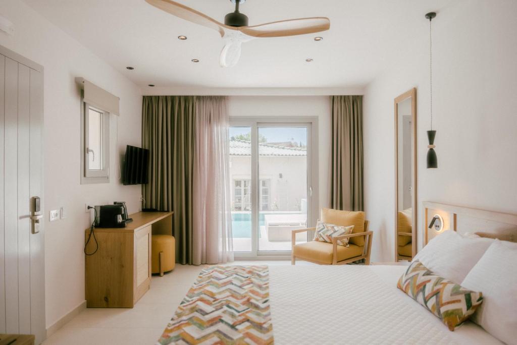 ein Hotelzimmer mit einem Bett und einem Balkon in der Unterkunft Eterrano Seaside Retreat in Parga