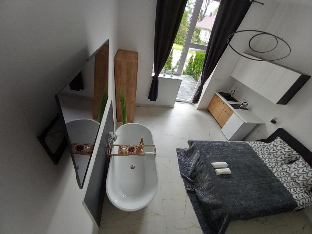 a white bathroom with a toilet and a sink at Roztoczańskie Apartamenty in Zwierzyniec