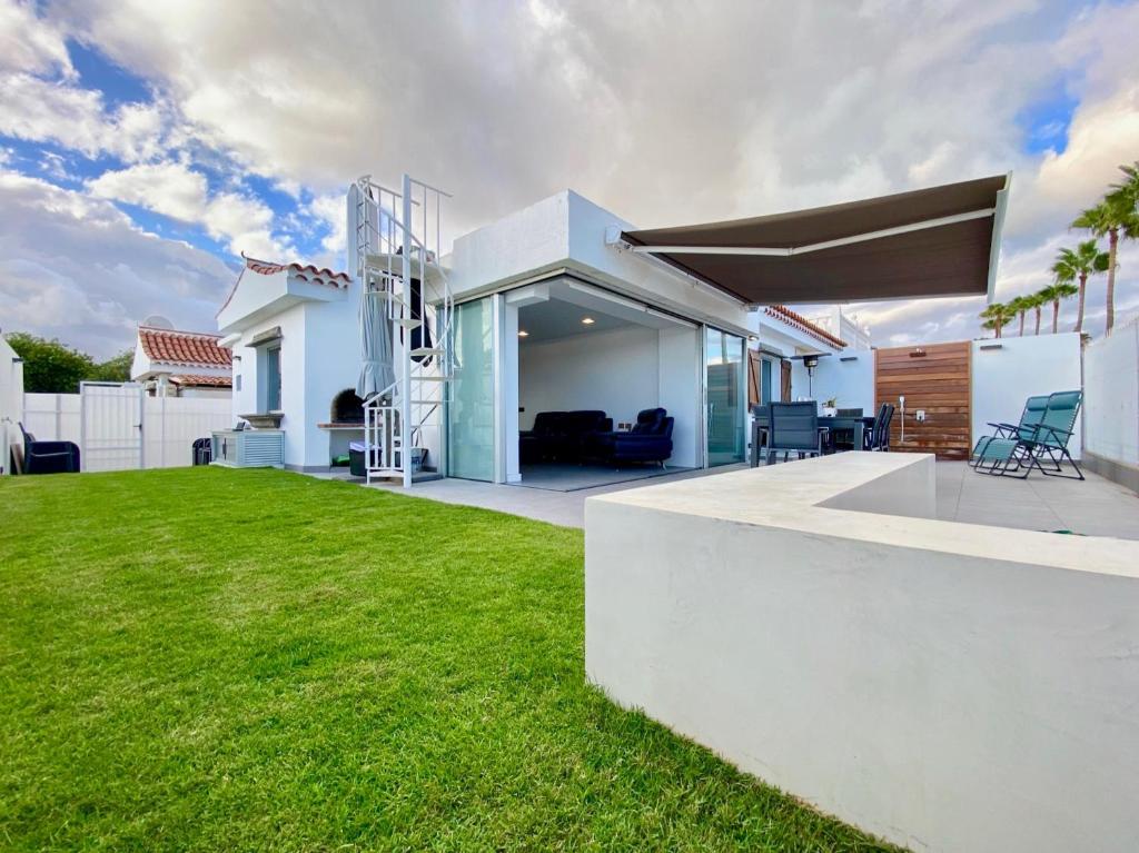 ein weißes Haus mit Rasen im Hof in der Unterkunft Sun golf house in Maspalomas