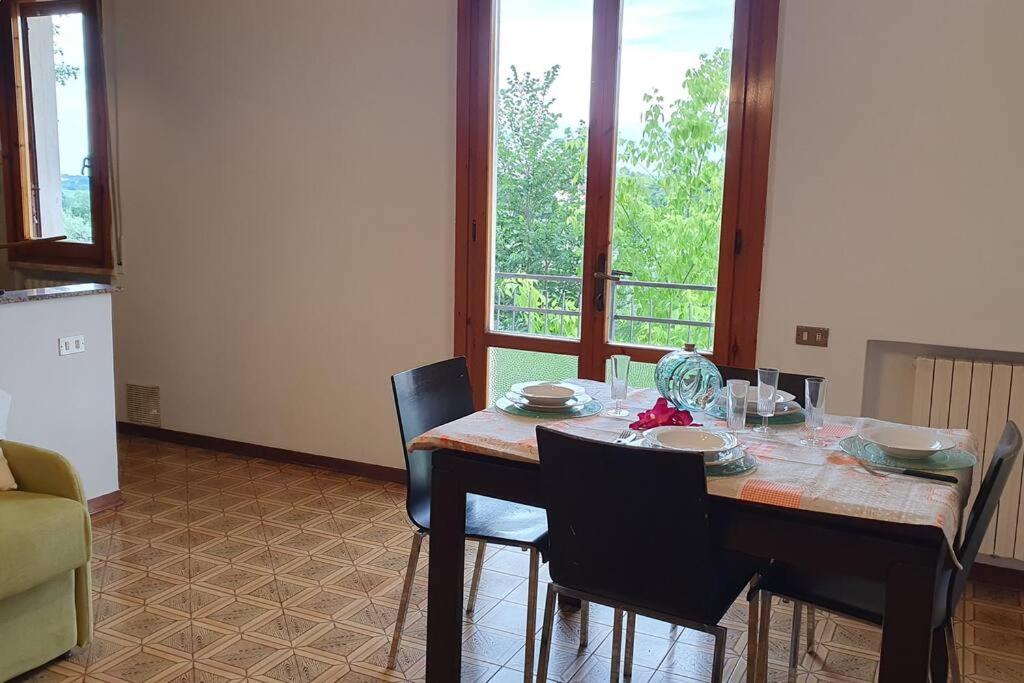 a dining room with a table with chairs and a window at Latte e Menta in Lamporecchio