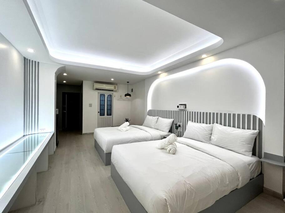um quarto de hotel com duas camas com almofadas brancas em DiscoveryHome2 at Pratunammarket em Bangkok