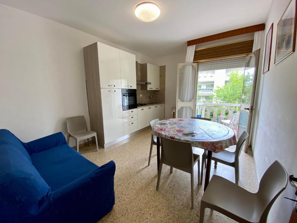 un soggiorno con divano blu e tavolo di Appartamento Pizzolitto a Caorle