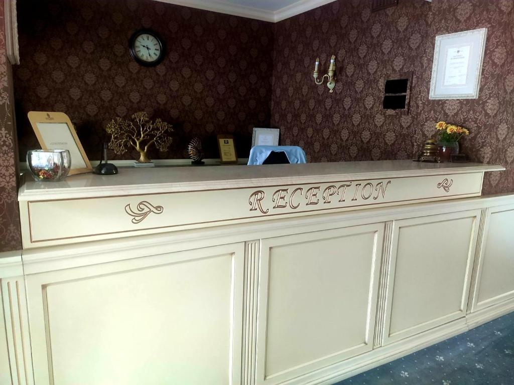 a white counter top with a clock on a wall at Savoy Hotel in Chişinău