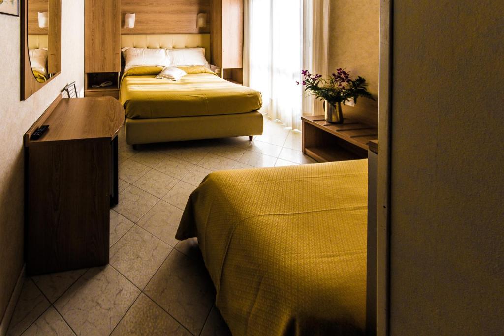 Habitación de hotel con 2 camas y ventana en Hotel Baviera, en Sottomarina