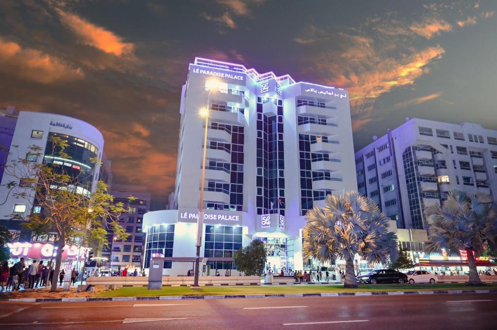 a large white building in a city at night at Le Paradise Palace in Dubai