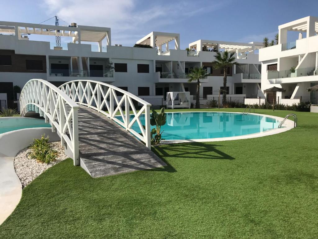 a bridge over a swimming pool in front of a building at 49 Laguna Beach in Torrevieja