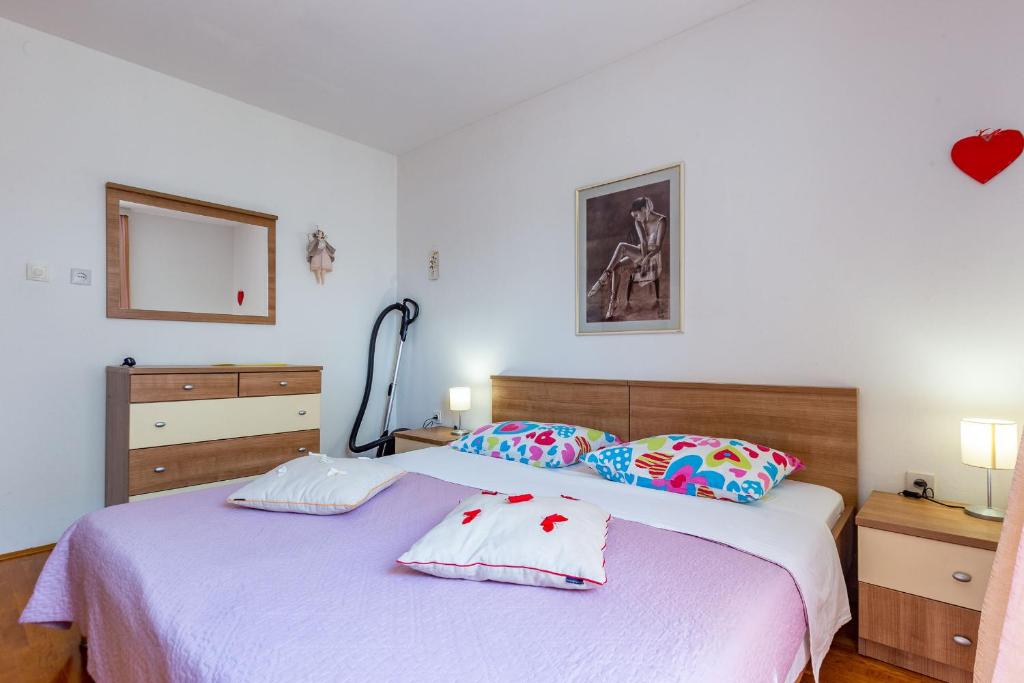 a bedroom with a bed with two pillows on it at Lanterna Puntamika apt. near beach in Zadar
