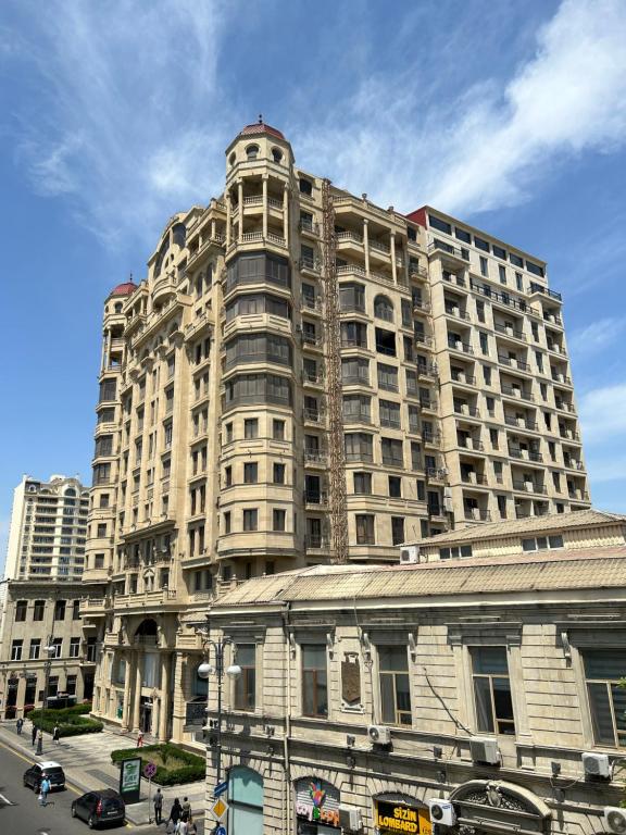 um grande edifício alto com uma rua em frente em Apartment on Nizami street em Baku