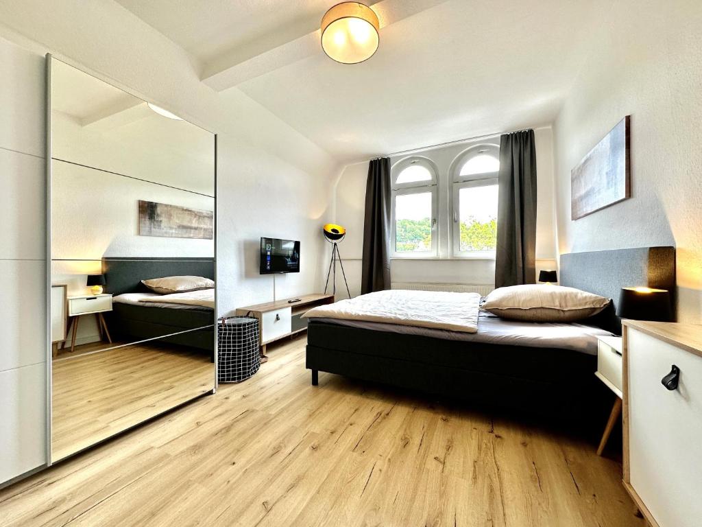 1 dormitorio con cama y espejo grande en Zentral gelegene DG-Wohnung mit 4 Schlafzimmern, en Eisenach