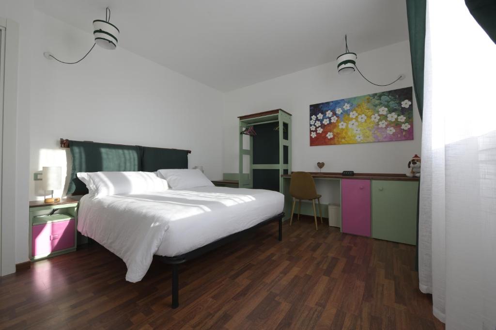 Monte San PietroにあるTerrazzaPonenteのベッドルーム(白い大型ベッド1台、デスク付)