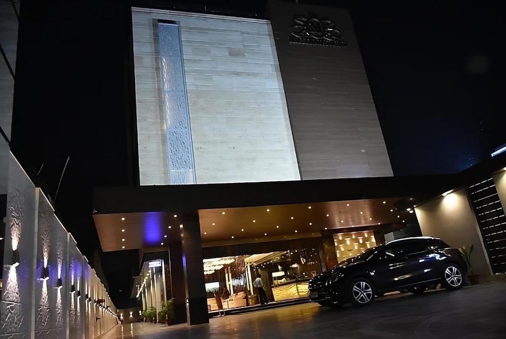 a car parked in front of a building at night at Hotel Millennium Inn, Prayagraj in Allahābād