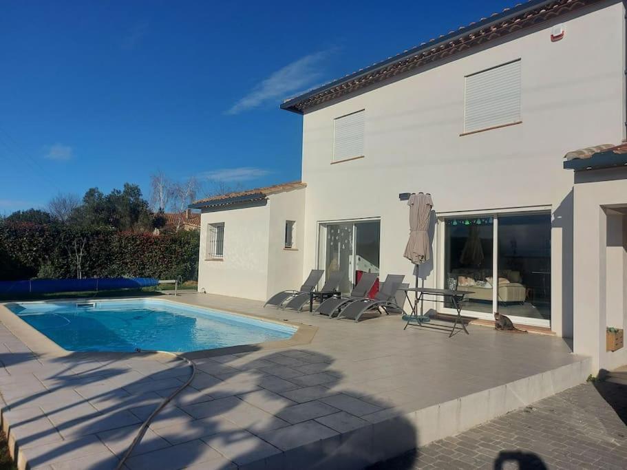 une villa avec une piscine et une maison dans l'établissement Studio neuf avec acces piscine, à Valergues