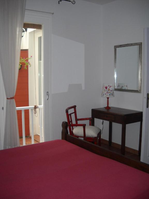 a bedroom with a bed and a table and a chair at B&B Il Gatto Pescatore in Stintino