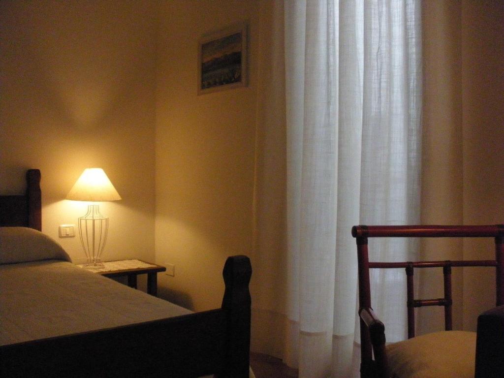 a bedroom with a bed and a lamp next to a window at B&B Il Gatto Pescatore in Stintino