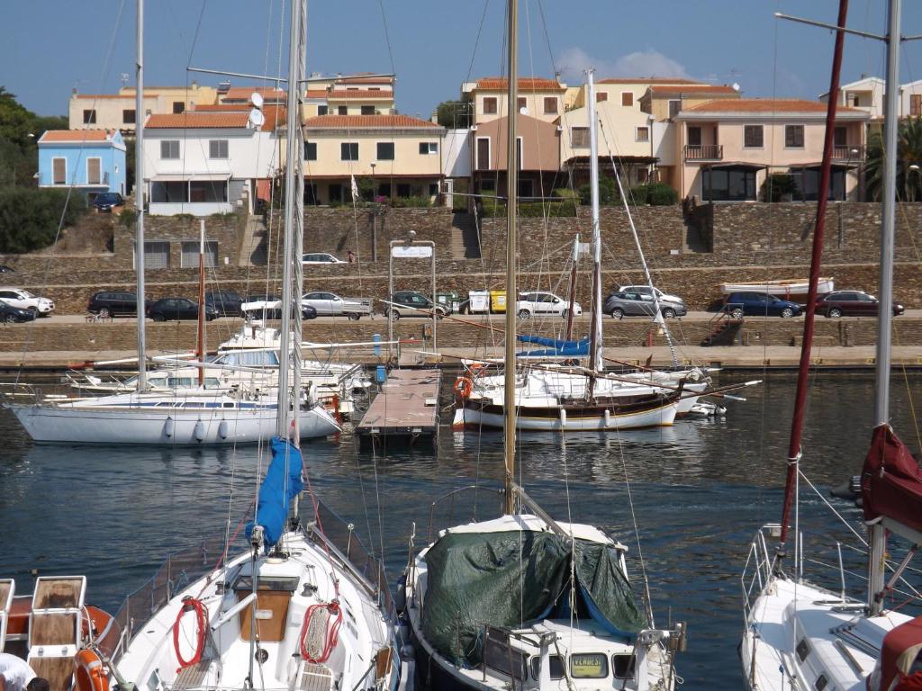 a group of boats docked in a harbor with buildings at B&B Il Gatto Pescatore in Stintino