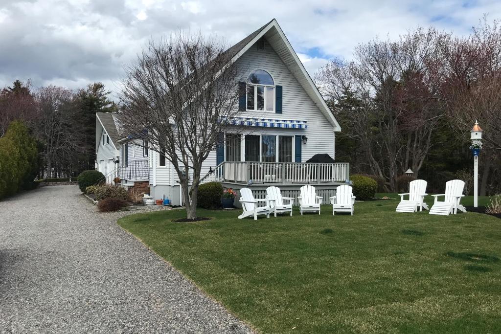 une maison avec des chaises blanches sur la pelouse dans l'établissement Nubble's Perch, à York