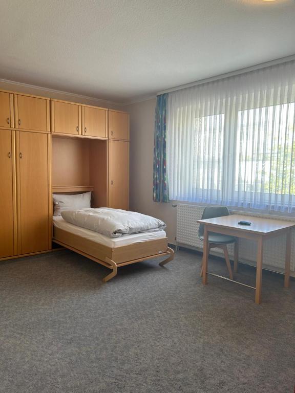 Schlafzimmer mit einem Bett, einem Schreibtisch und einem Tisch in der Unterkunft Haus Tida in Norderney