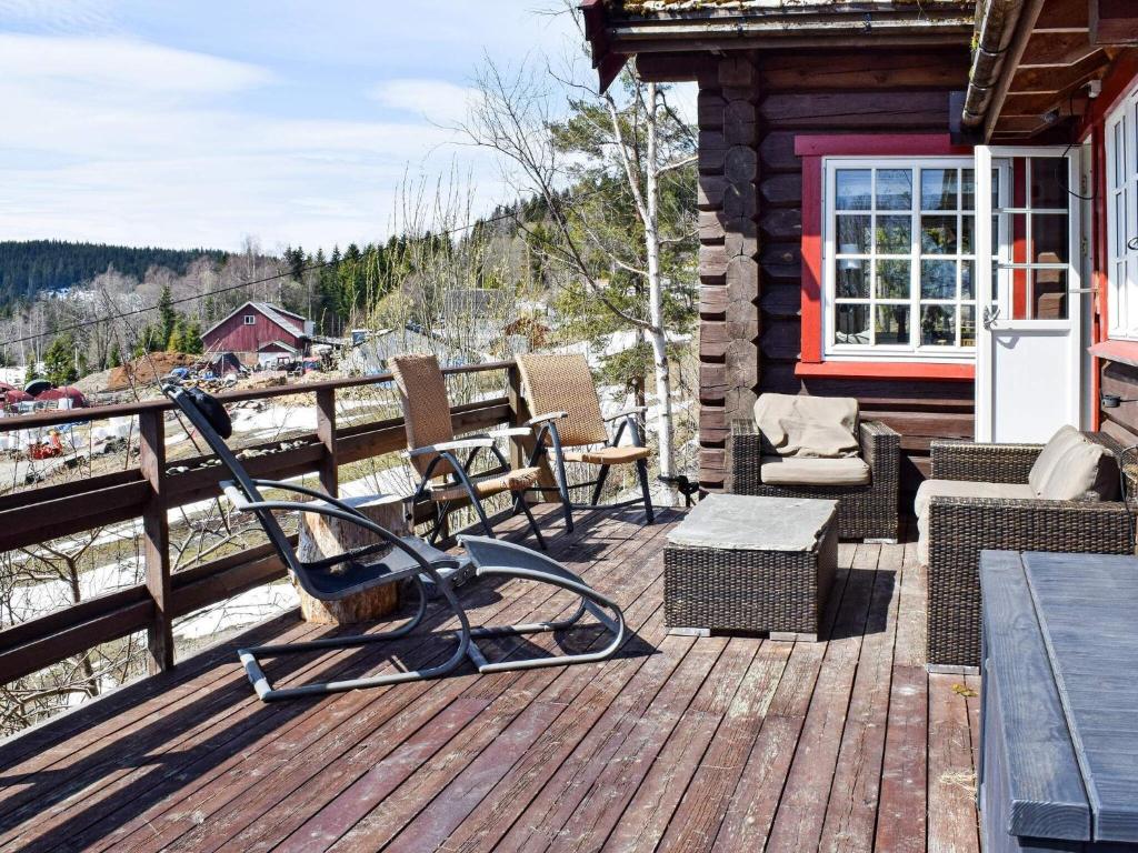 una terrazza in legno con sedie e tavoli su una cabina di Holiday home HURDAL II a Hurdal