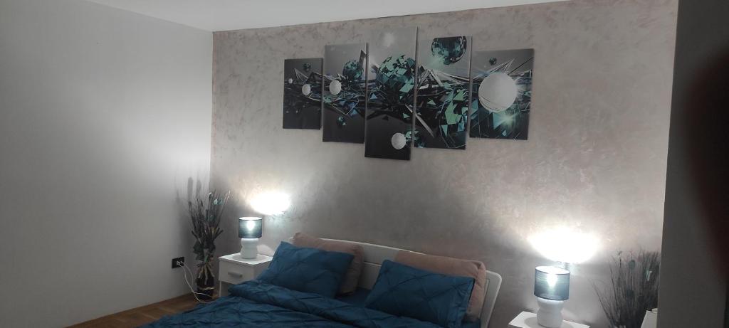 een woonkamer met een blauwe bank en foto's aan de muur bij SOPHIA Central Studio in Hunedoara