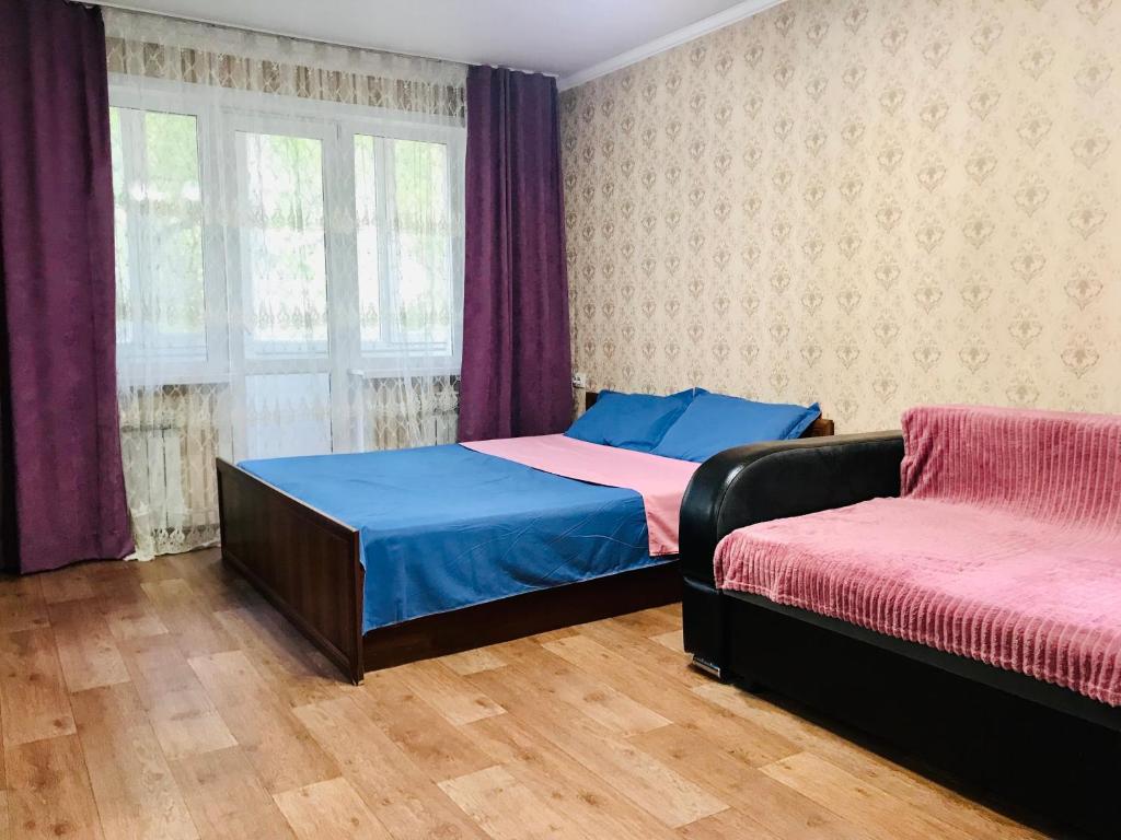 a bedroom with a bed and a couch at Apartaments in the city center in Karagandy