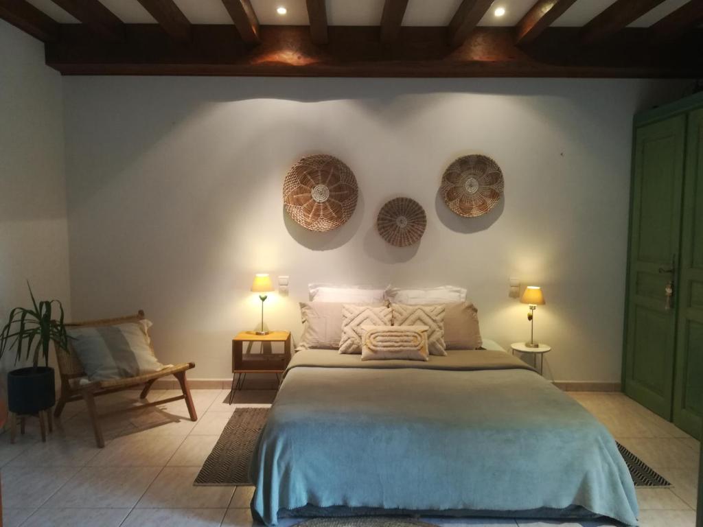 - une chambre avec un grand lit et 2 assiettes murales dans l'établissement Le Baron Perché, à Saint-Cyprien