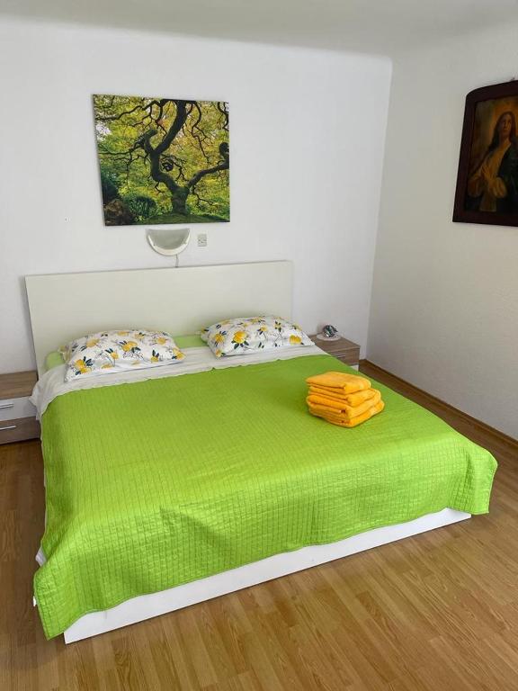 a bedroom with a green bed with a green blanket at Đana in Cres