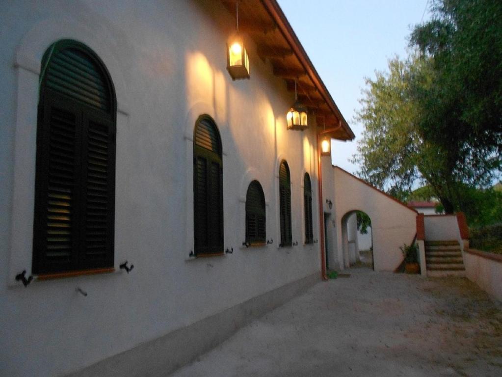 a white building with black windows and a street at Feudo di Plutino in Parghelia