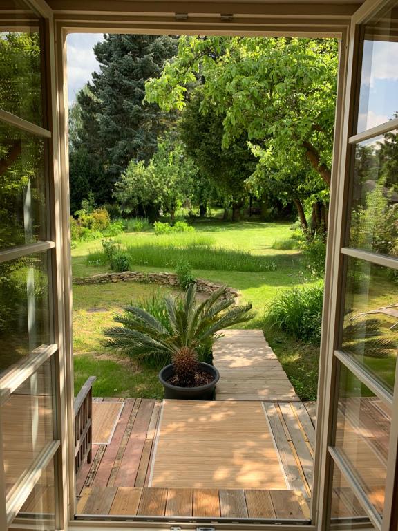 an open door to a patio with a potted plant at Idyllische Fewo Belling Spa - eigene Sauna und E-Ladesäule in Dresden