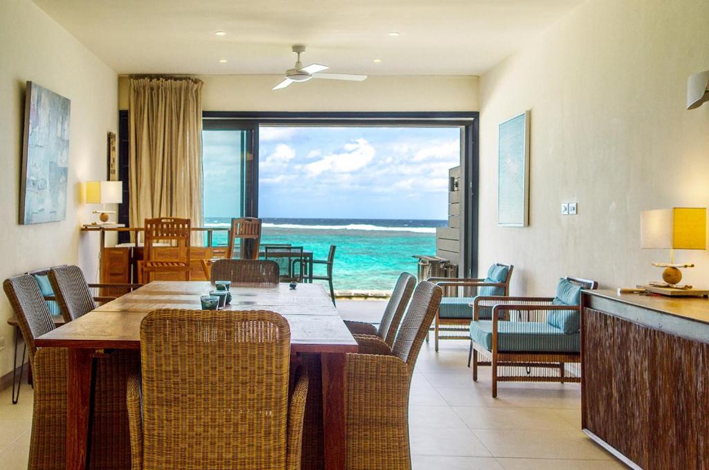 a dining room with a table and a view of the ocean at Coral Bay by Dream Escapes in Blue Bay