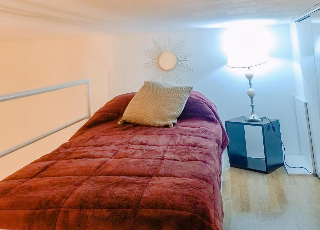Dormitorio con cama con almohada y lámpara en Departamento Loft en Cañitas Palermo Hollywood en Buenos Aires