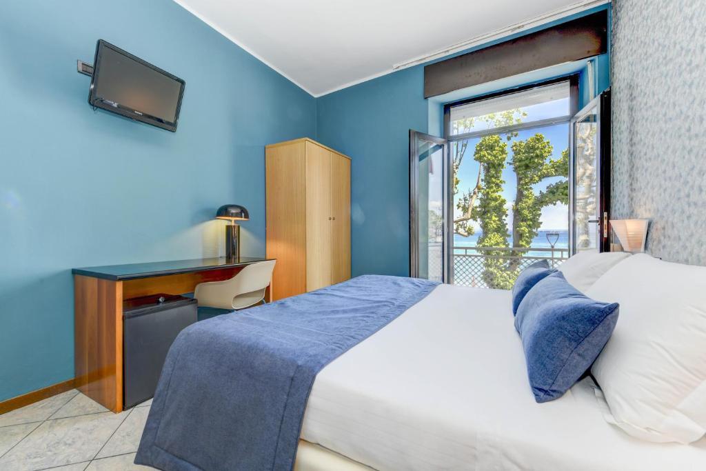 um quarto com uma cama grande e uma janela em Hotel Aurora em Desenzano del Garda