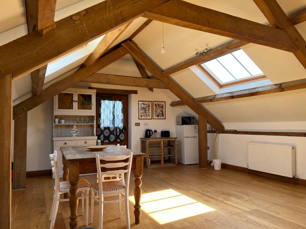 a kitchen with a table and chairs and a window at The Old Stable Block - Flat 2 in Wadebridge