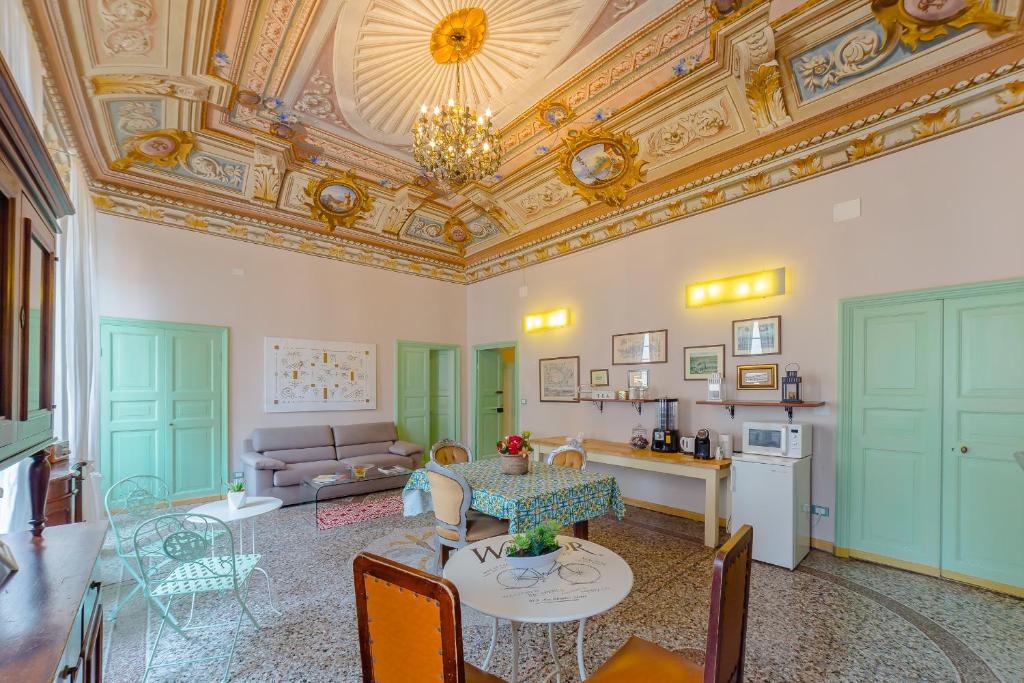 sala de estar con techo artesonado, mesa y sillas en B&B Bernini, en Finale Ligure