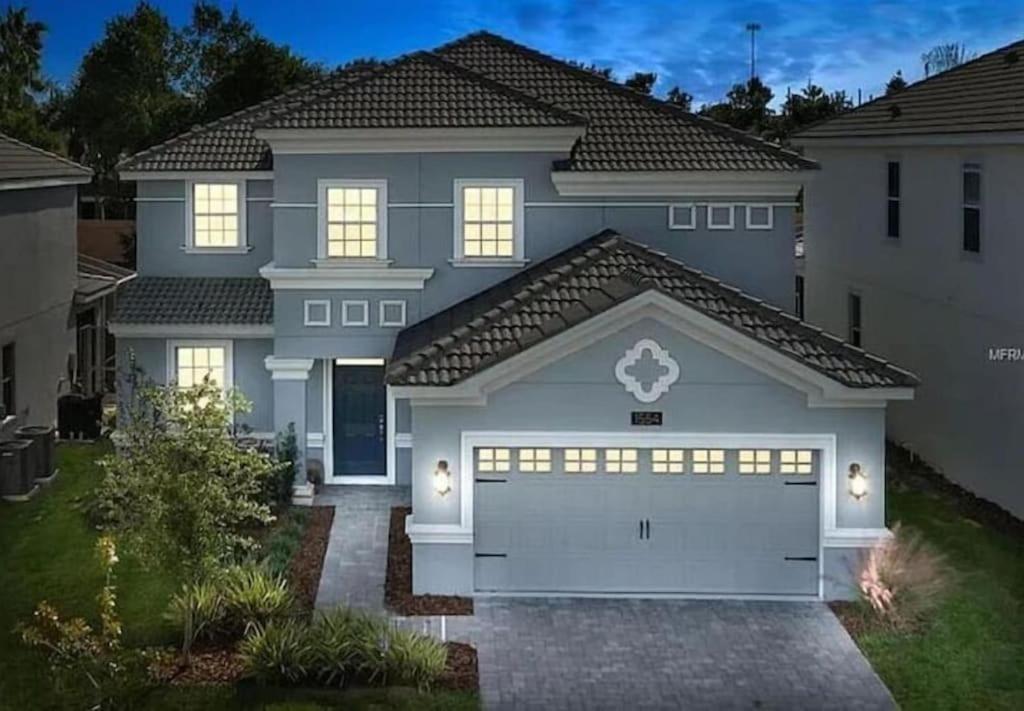 uma casa grande com uma garagem branca em Villa at Champions Gate Resort in Orlando near Theme Parks with Private Pool, SPA & Movie Theater em Davenport