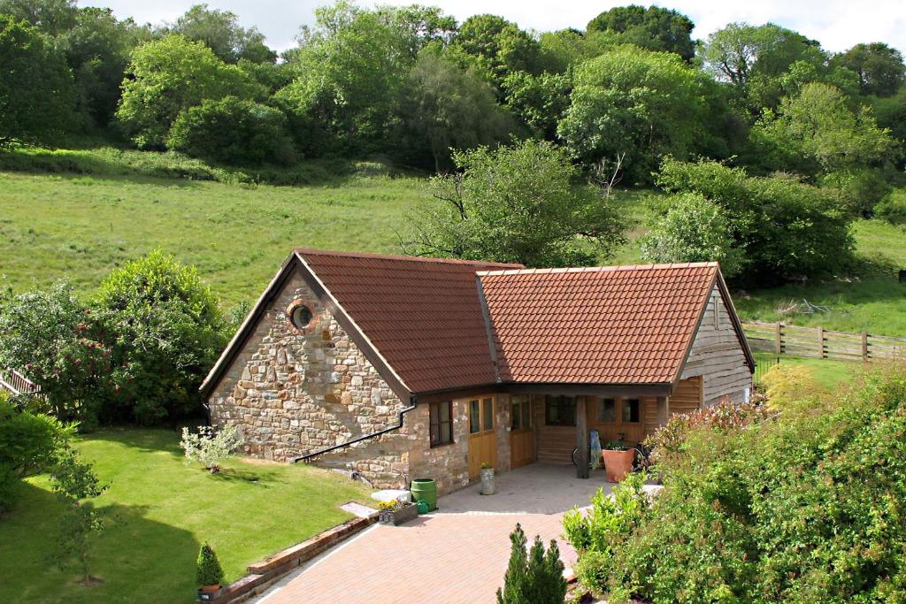ein kleines Steinhaus mit braunem Dach in der Unterkunft Stables in Little Dean