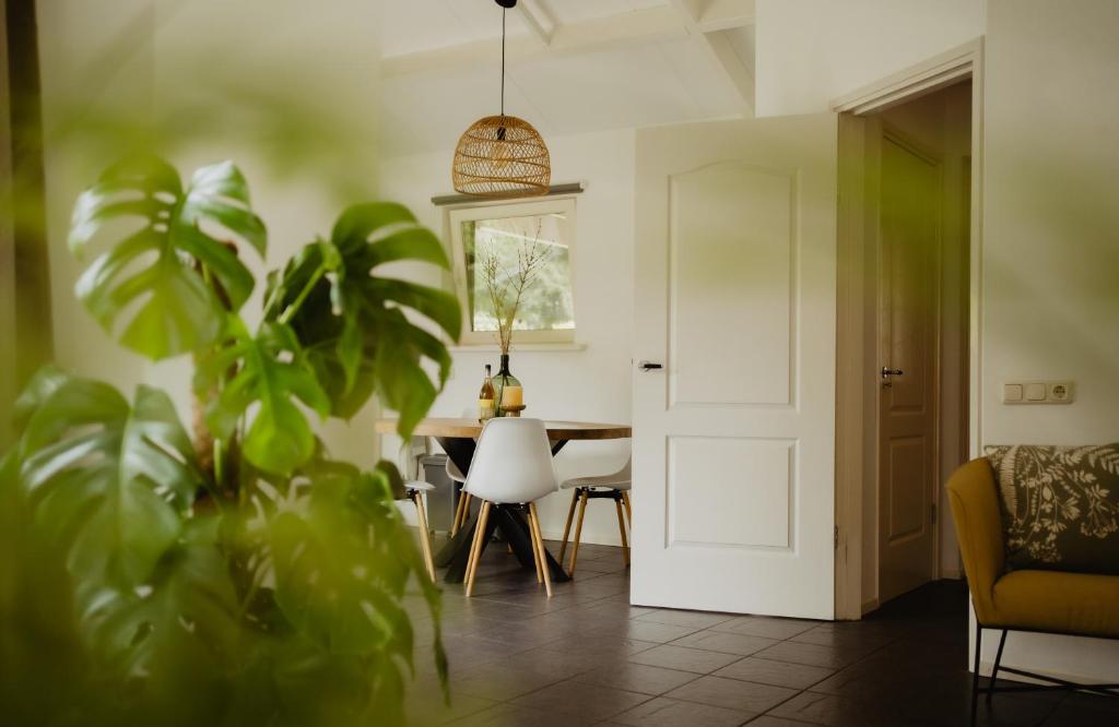 sala de estar con mesa, sillas y planta en Bungalow Rondomzon, en Putten