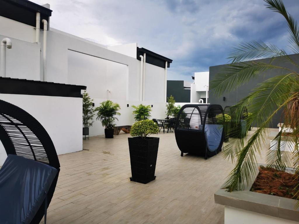 a patio with chairs and plants on a building at Stylish Micasa 4 Home 3BR+FREE PARKING -Hann's Residence in Sibu