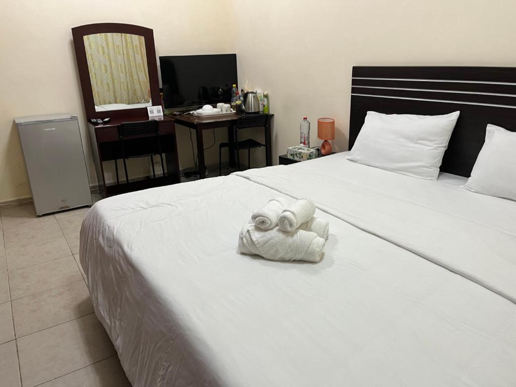 Un dormitorio con una cama con una toalla. en Master room attached bathroom, en Dubái